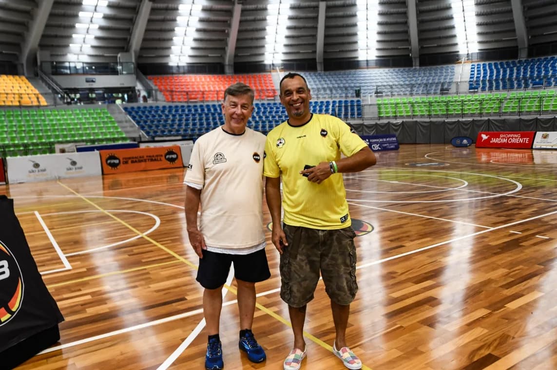 Dois participantes na quadra de um ginásio de basquete